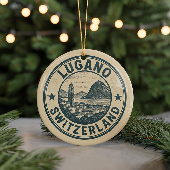 A circular ornament with the text "LUGANO SWITZERLAND" and an illustration of a Swiss mountain range, hanging from a string.