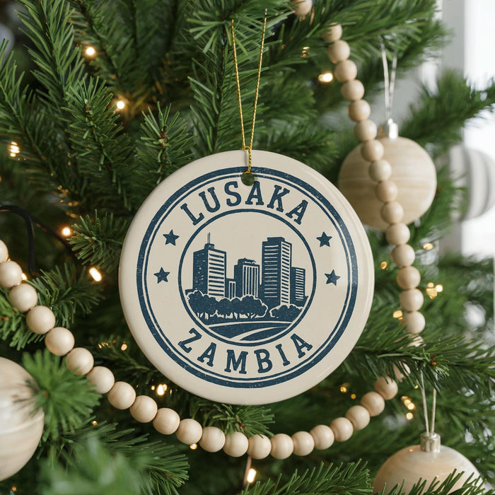 A circular ornament on a Christmas tree, featuring the text "LUSAKA ZAMBIA" and a graphic of a city skyline.