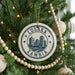 A circular ornament on a Christmas tree, featuring the text "LUSAKA ZAMBIA" and a graphic of a city skyline.
