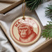 A round ornament with a monkey's face on it, hanging from a string.