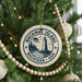 A Christmas tree decorated with ornaments, including a circular ornament with the text "Mackinac Island, Michigan, USA" and a lighthouse image.