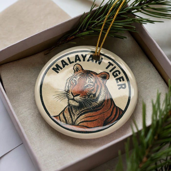 A circular ornament featuring a tiger's image, placed in a box with pine branches.