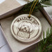 A ceramic ornament in a box, featuring a Maltese dog illustration.