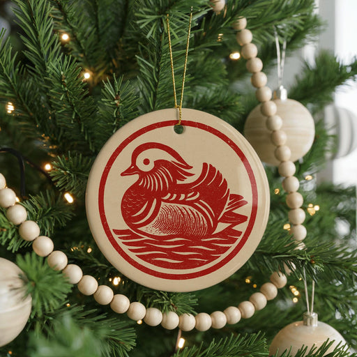 A Christmas tree decorated with ornaments, including a red and white ornament featuring a duck design.