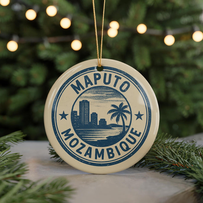 A circular ornament with the text "MAPUTO MOZAMBIQUE" and a graphic of a city skyline, surrounded by Christmas lights and greenery.