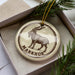 A circular ornament with a brown and white design featuring a goat, and the word "MARKHOR" written on it.
