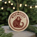 A round ornament with a monkey image and the word "MARMOSET" written on it, hanging from a string.
