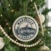 A Christmas tree decorated with ornaments, including a circular ornament with the text "MARSÉILLE FRANCE" and a castle illustration.