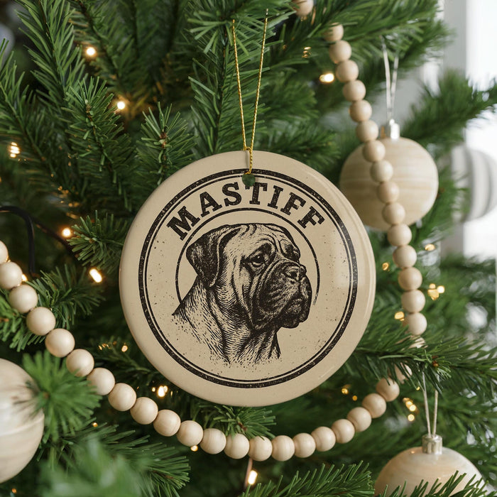 A Christmas tree decorated with ornaments, including a circular ornament with a dog's face and the word "Mastiff" written on it.