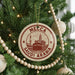 A Christmas tree decorated with ornaments, including a circular ornament with the text "M Mecca Saudi Arabia" and a mosque illustration.