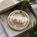 A circular ornament with the text "MEDINA SAUDI ARABIA" printed on it, surrounded by pine branches.