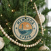 A Christmas tree decorated with ornaments, including a circular ornament with the text "MENORCA SPAIN" and a lighthouse image.