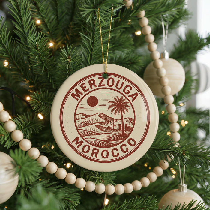 A round ornament on a Christmas tree with the text "MERZOUGIA MOROCCO" printed on it.