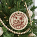 A round ornament on a Christmas tree with the text "MERZOUGIA MOROCCO" printed on it.