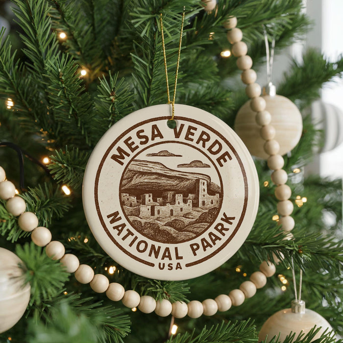 A Christmas tree decorated with ornaments, including a circular ornament with the text "Mesa Verde National Park" and a beaded ornament.