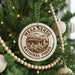 A Christmas tree decorated with ornaments, including a circular ornament with the text "Mesa Verde National Park" and a beaded ornament.