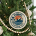 A round ornament on a Christmas tree with the text "MIAMI FLORIDA USA" and a graphic of a city skyline with palm trees.
