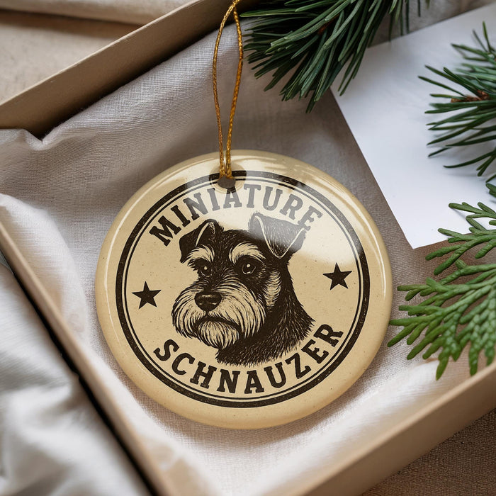A round ornament with a dog's head and the text "MINIATURE SCHNAUZER" printed on it, hanging from a string.