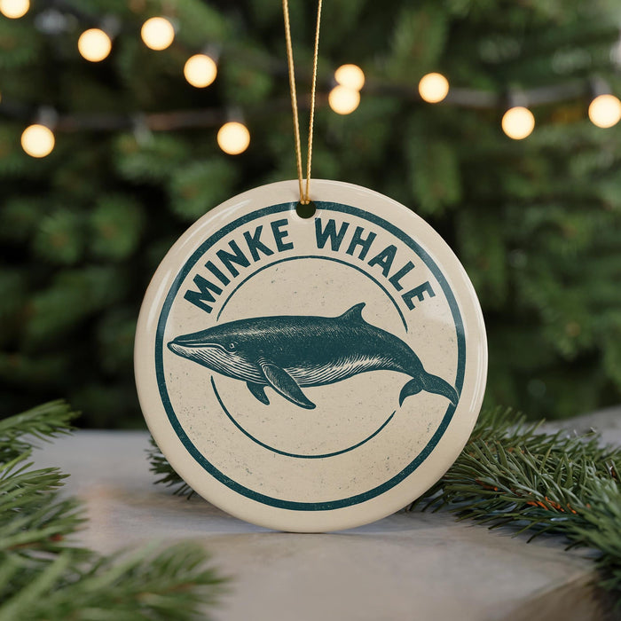 A round ornament with a graphic of a whale and the text "MINKE WHALE" on it, hanging from a string.