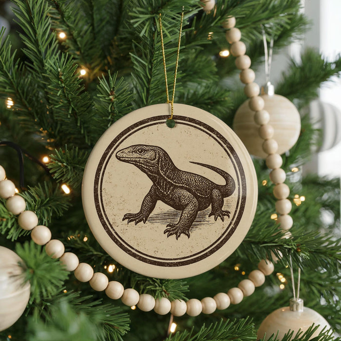 A Christmas tree decorated with ornaments, including a circular ornament featuring a lizard design.