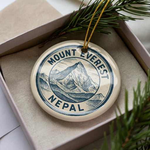 A decorative ornament in a box, featuring a mountain landscape and the text "Mount Everest Nepal".