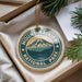 A round ornament with the text "MOUNT RAINIER NATIONAL PARK" and a mountain landscape design, hanging from a string.