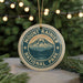 A circular ornament with the text "Mount Rainier National Park" and a mountain landscape design, hanging from a string.
