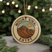 A circular ornament with the text "Mount Sinai Egypt" and an illustration of a mountain range, hanging from a string.