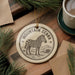 A decorative ornament featuring a zebra standing in a grassy field, with the text "MOUNTAIN ZEBRA" around the image.