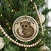 A Christmas tree decorated with ornaments, including a round ornament featuring a cartoon image of a mouse and the text "MOOSE LEMUR".