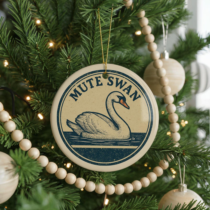 A round ornament on a Christmas tree featuring a swan, with the text "MUTE SWAN" displayed on it.