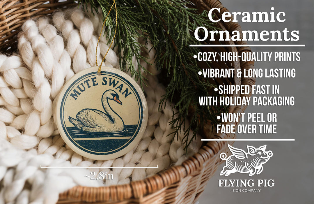 Ceramic ornaments, featuring a ceramic swan ornament with a wicker basket and pine branches, are displayed on a bed of white yarn.