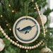 A Christmas tree decorated with ornaments, including a circular ornament featuring a blue and white image of a narwhal.