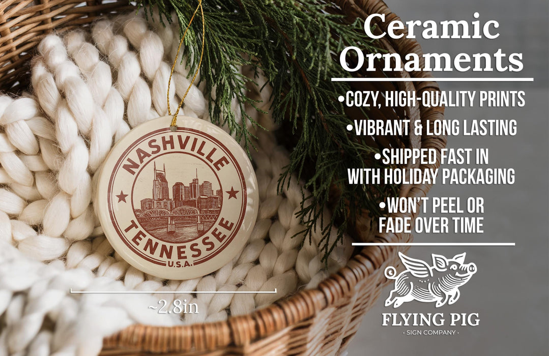 Ceramic ornaments, including a Tennessee ornaments, are displayed in a basket with pine branches.