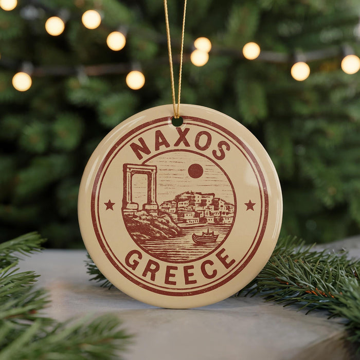 A circular ornament with the text "NAXOS GREECE" and an illustration of a Greek island, surrounded by Christmas lights and greenery.