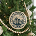 A Christmas tree decorated with ornaments, including a circular ornament with the text "NEUSSCHWANSTEIN CASTLE GERMANY" and a castle illustration.