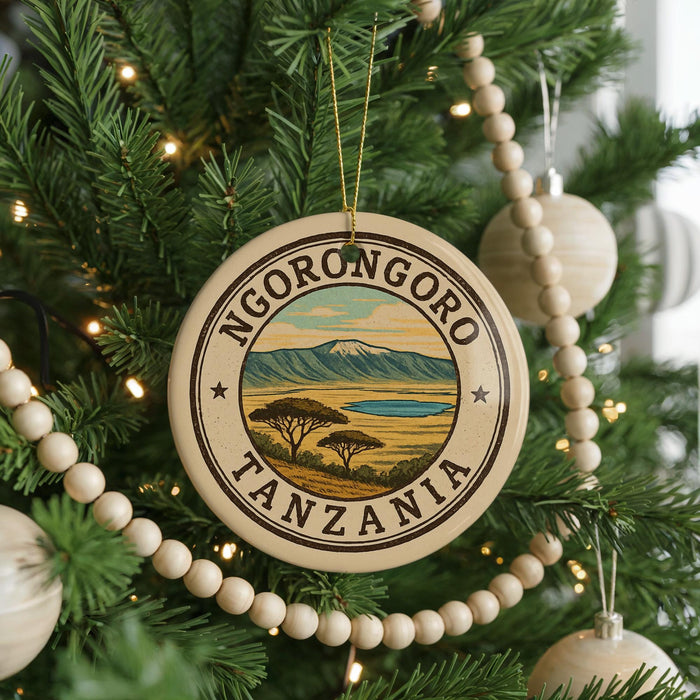 A circular ornament on a Christmas tree, featuring the text "NGORONGOORO TANZANIA" and an illustration of a landscape with mountains and a lake.