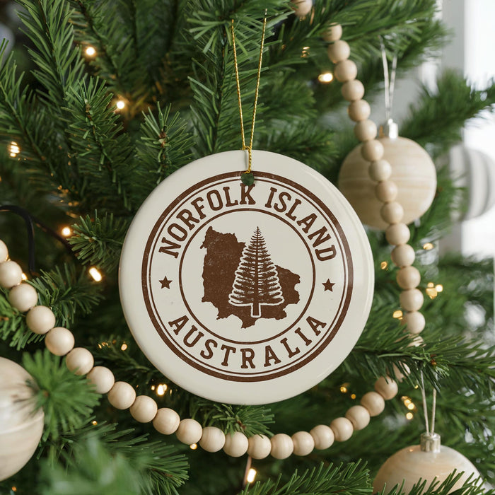 A Christmas tree decorated with ornaments, including a circular ornament with the text "NORFOLK ISLAND AUSTRALIA" and a tree-like design.