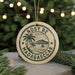 A circular ornament with a palm tree and a sailboat, surrounded by the text "NOSY BE MADAGASCAR".
