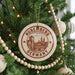 A Christmas tree decorated with ornaments, including a circular ornament with the text "Nuremberg Germany" and a wooden bead decoration.