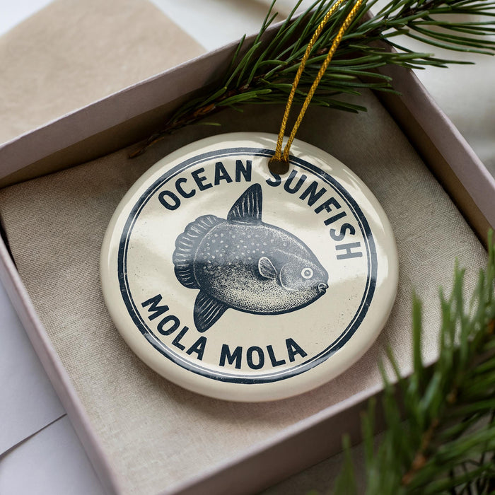 A circular ornament with the text "OCEAN SUNFISH MOLA MOLA" printed on it, surrounded by a decorative string.