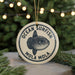 A circular ornament with the text "OCEAN SUNFISH MOLA" and an illustration of a sunfish is displayed on a table, with a blurred background of a Christmas tree.