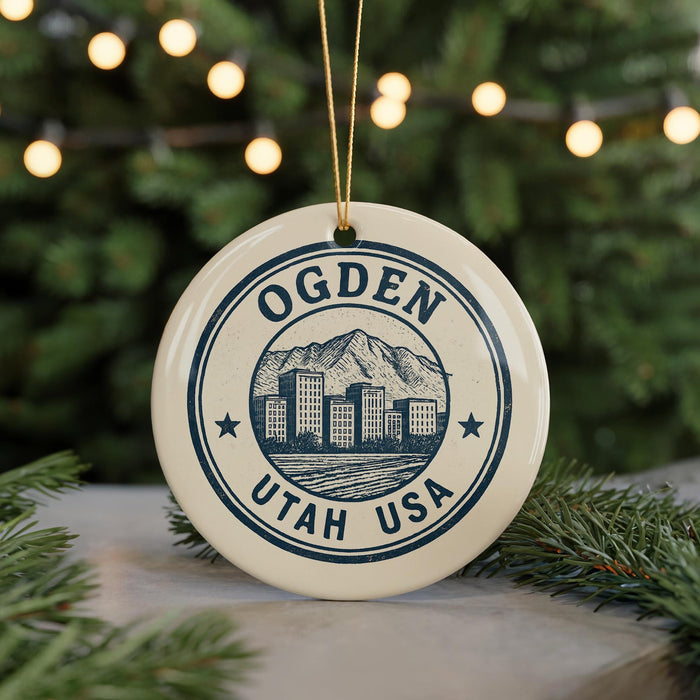 A circular ornament with the text "OGDEN UTAH USA" and an illustration of a cityscape with mountains in the background, hanging from a string.