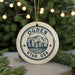 A circular ornament with the text "OGDEN UTAH USA" and an illustration of a cityscape with mountains in the background, hanging from a string.