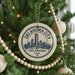 A circular ornament on a Christmas tree, featuring the text "OKLAHOMA CITY USA" and an illustration of the city skyline.