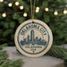 A circular ornament with the text "OKLAHOMA CITY, OK" and "OKLAHOMA USA" printed on it, along with a graphic of a city skyline.