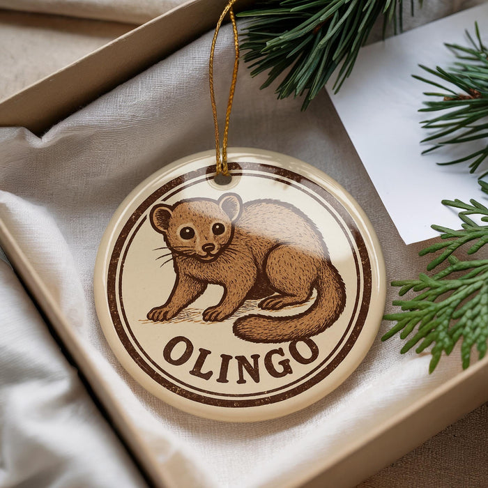 A round ornament with a brown animal, possibly a rodent or small mammal, on it, placed in a box with pine branches.