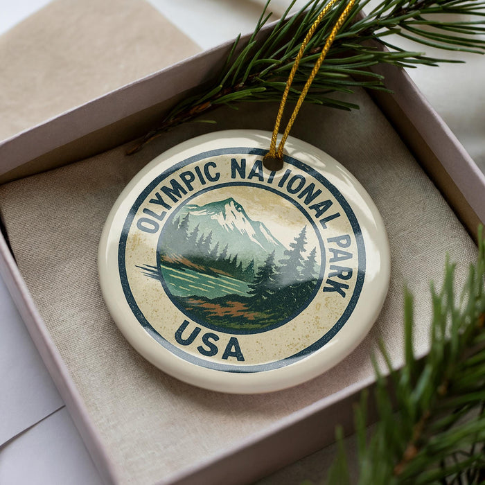 A circular ornament with the text "Olympic National Park USA" printed on it, surrounded by pine branches.