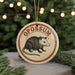 A circular ornament with the word "OPOSSIUM" printed on it, featuring an illustration of a raccoon or opossum.