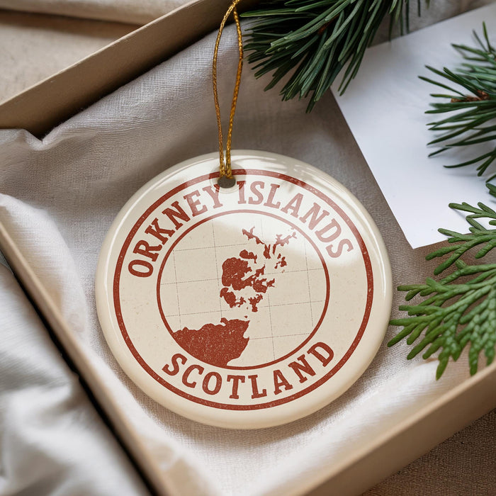 A circular ornament with the text "OKNEY ISLANDS SCOTLAND" printed on it, hanging from a string.